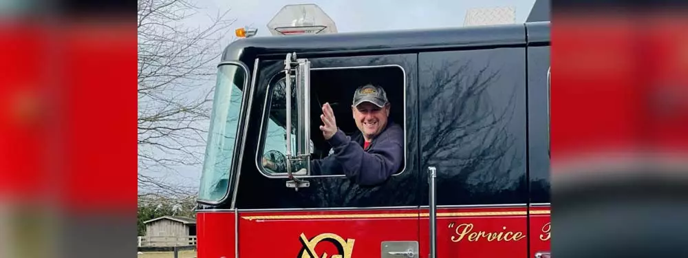 Volunteer fireman waving from drivers seat