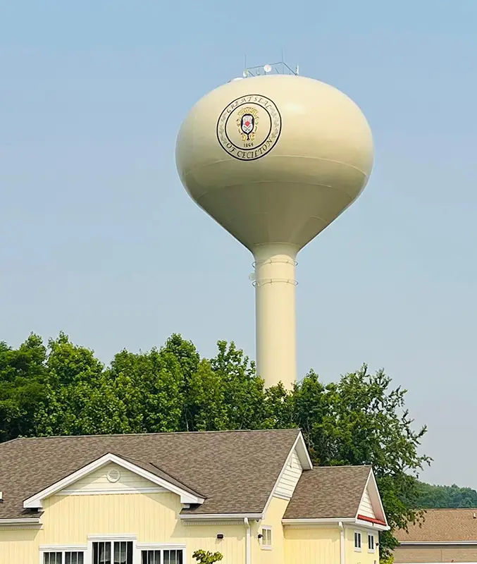 Cecilton water tower peaking above house and trees